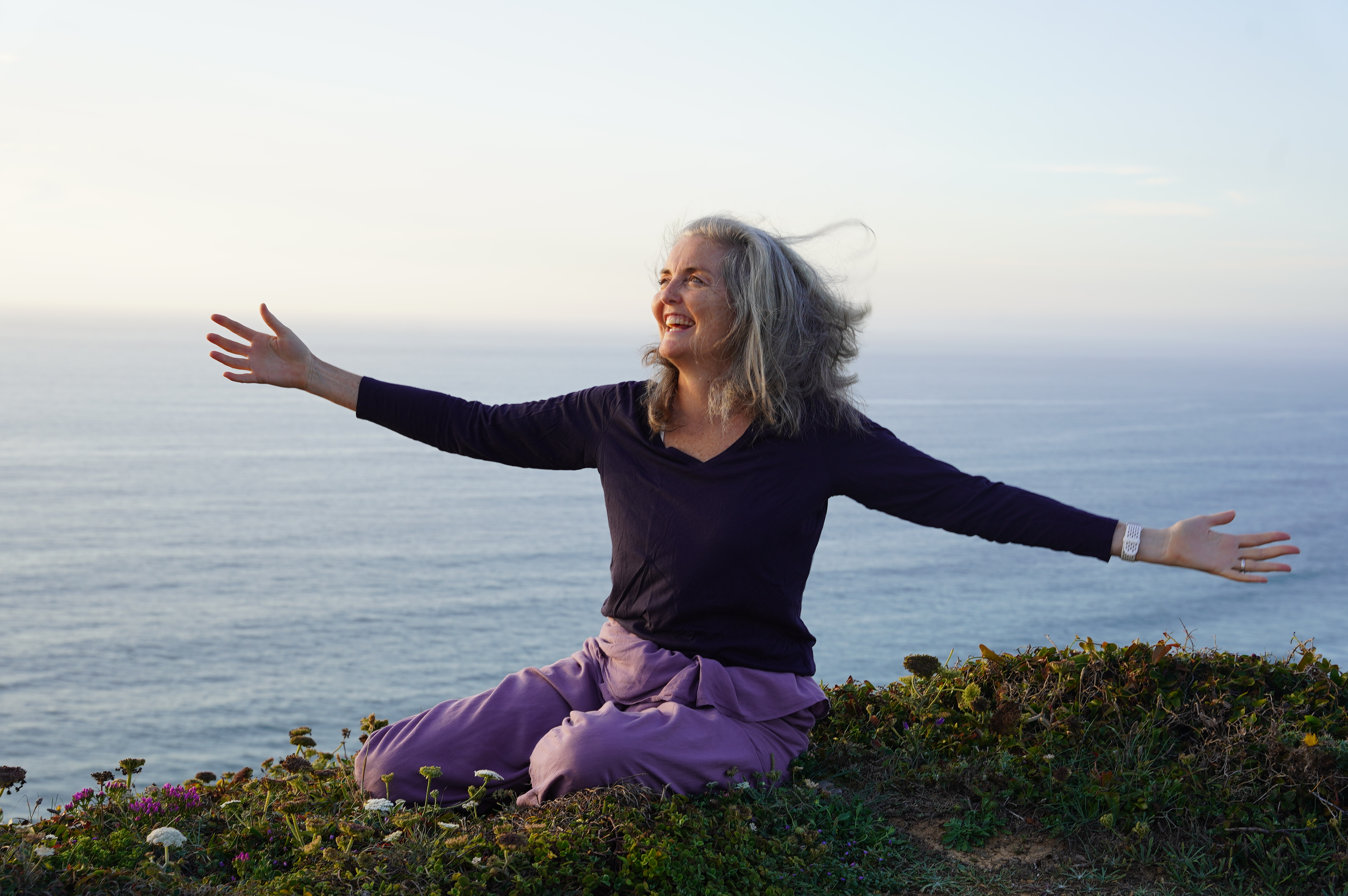 Georgia Marnham practicing yoga on the Portuguese coast, embodying the joy and freedom of Iyengar Yoga