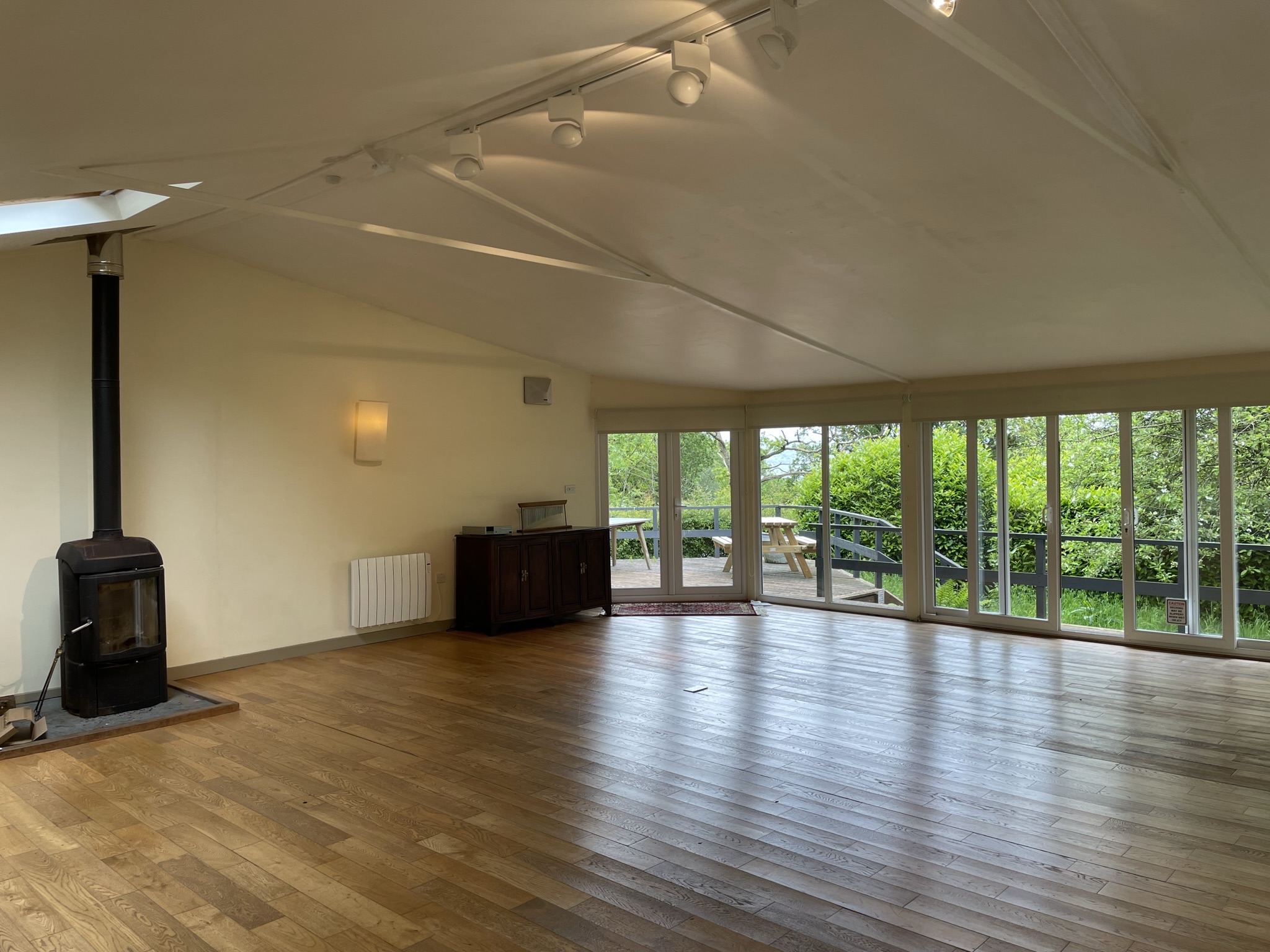 Spacious yoga studio at Yewfield with wooden floors, vaulted ceiling, and panoramic windows